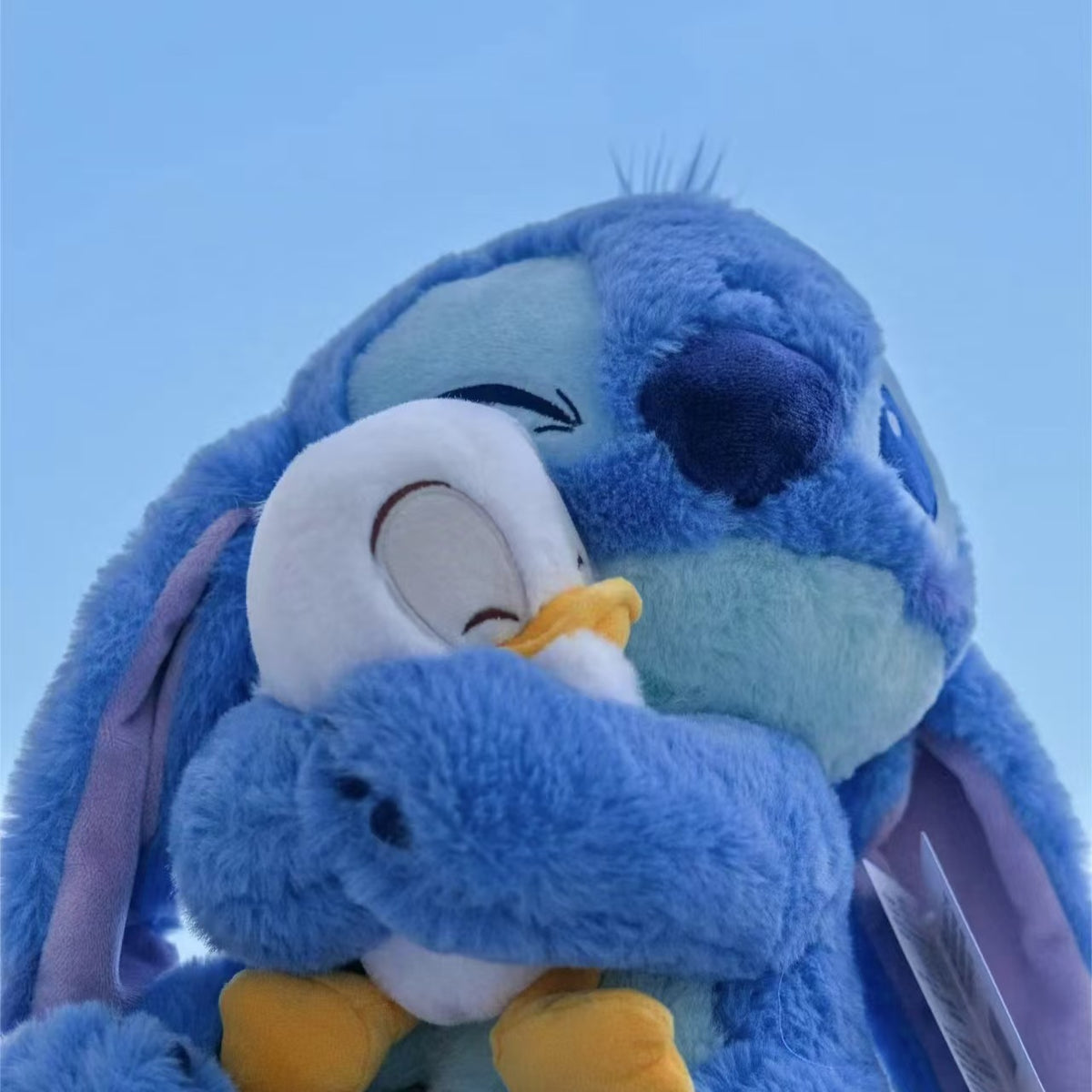 Peluche stitch bleu doux câlinant un ami