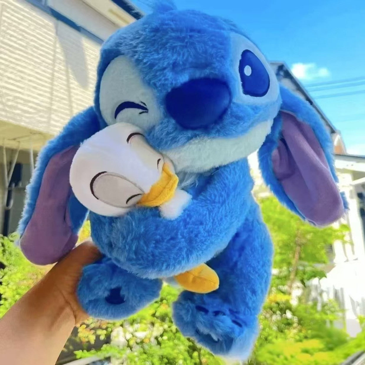 Peluche stitch bleu doux câlinant un ami
