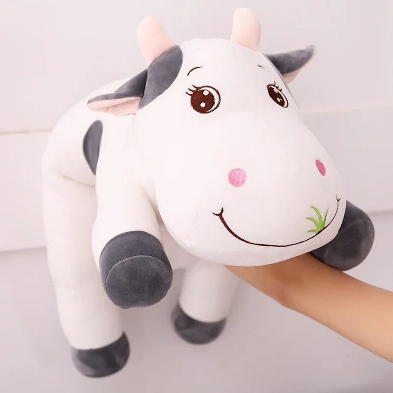 Peluche vache coloré qui broute de l'herbe